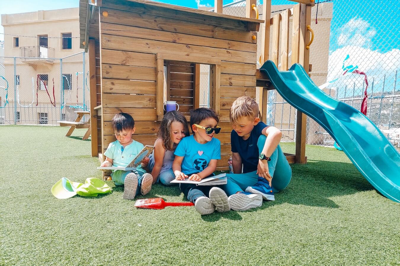 A small group of young children sitting in a Boundless Life playground - WASC accreditation