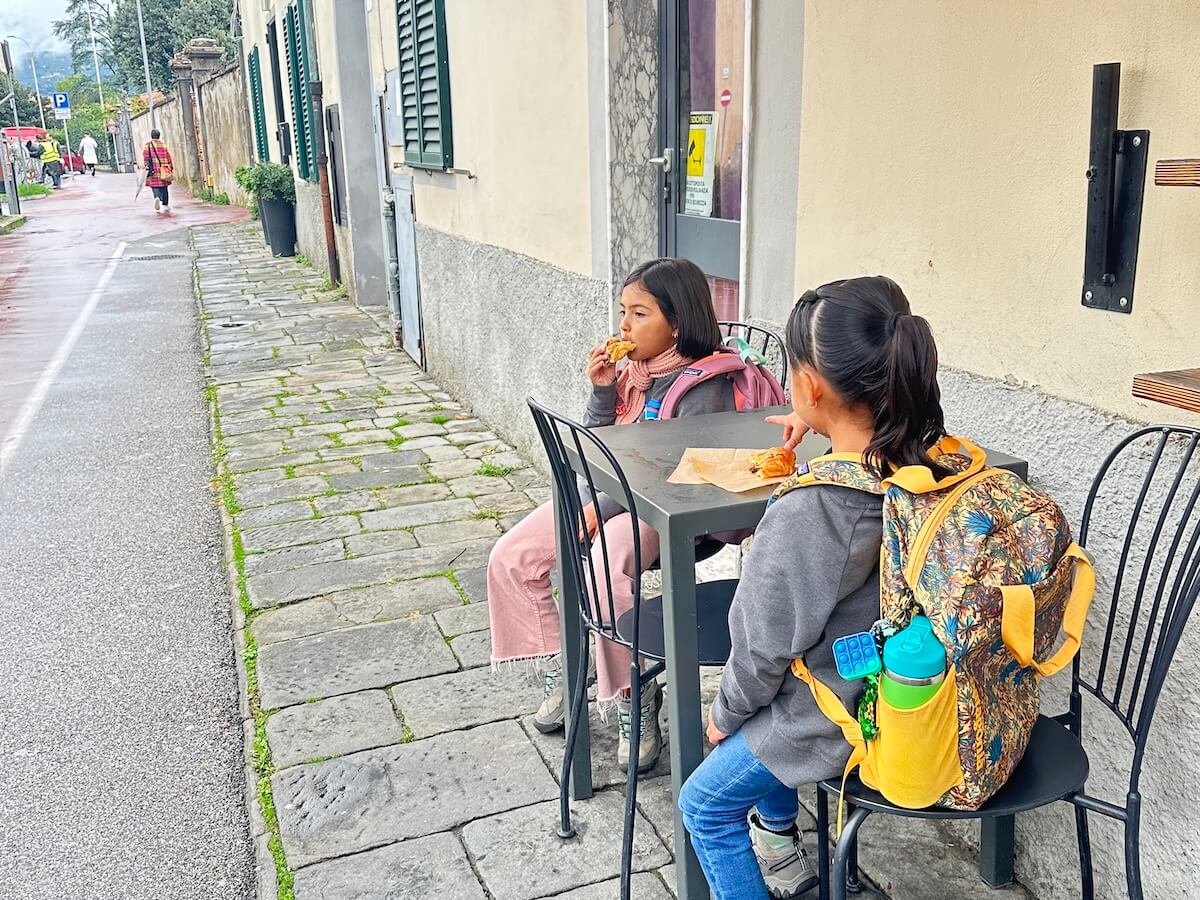Two girls eating pastries in the streets of Pistoia Italy on their way to the Boundless Life Education Center