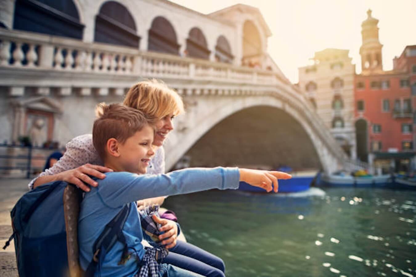 A traveling mother and son point to sights in a European city