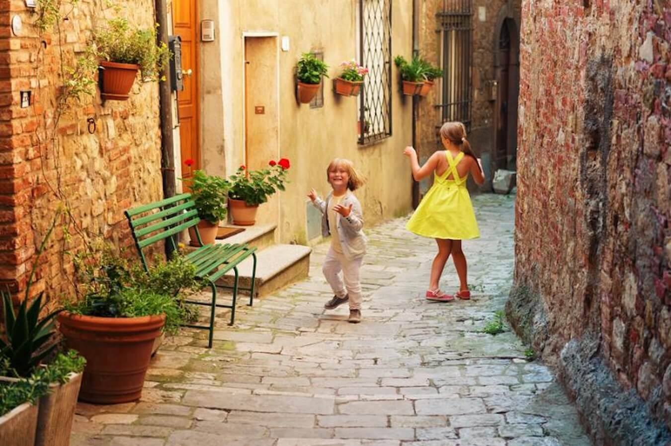 Two girls play joyfully  in a European street while traveling overseas