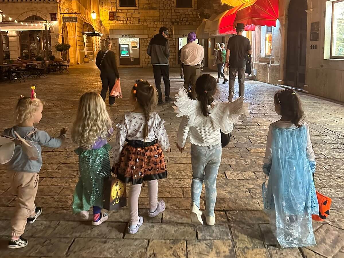 A group of children walk through Kotor Montenegro on Halloween - building a new global generation