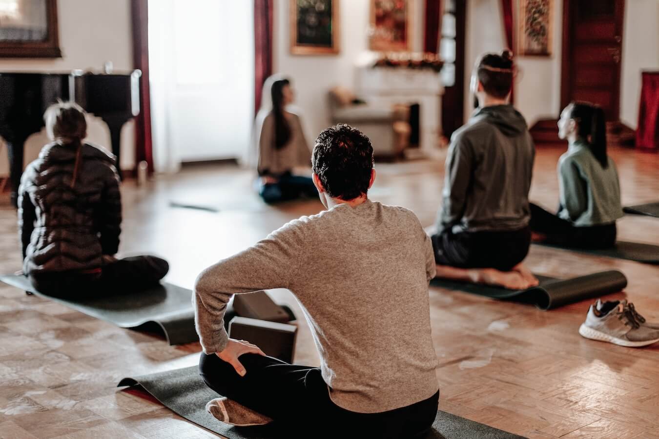 A group of adults participate in yoga while traveling - great coping strategy against homesickness