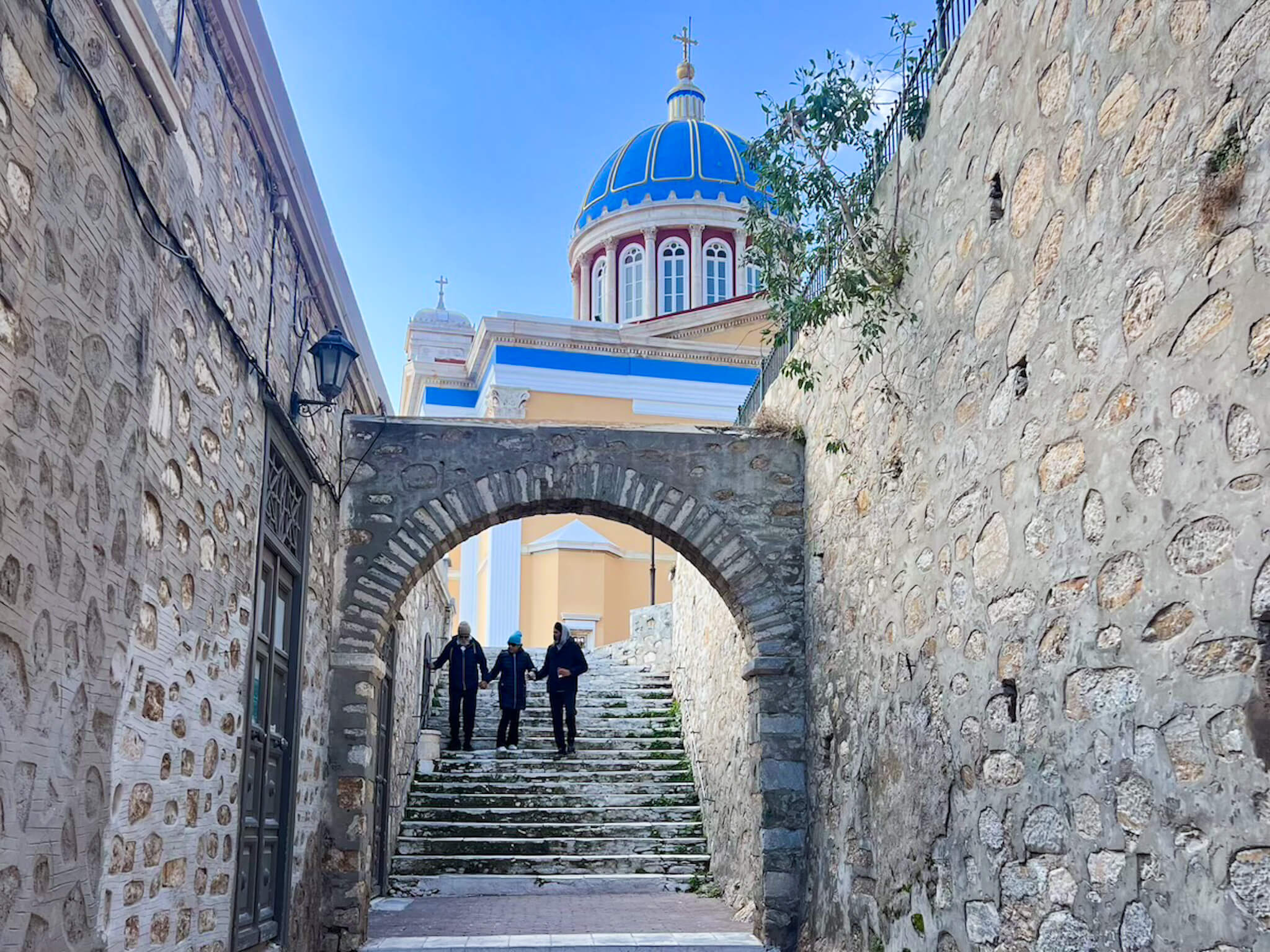 A family walk down the steps of Syros, exploring travel and education