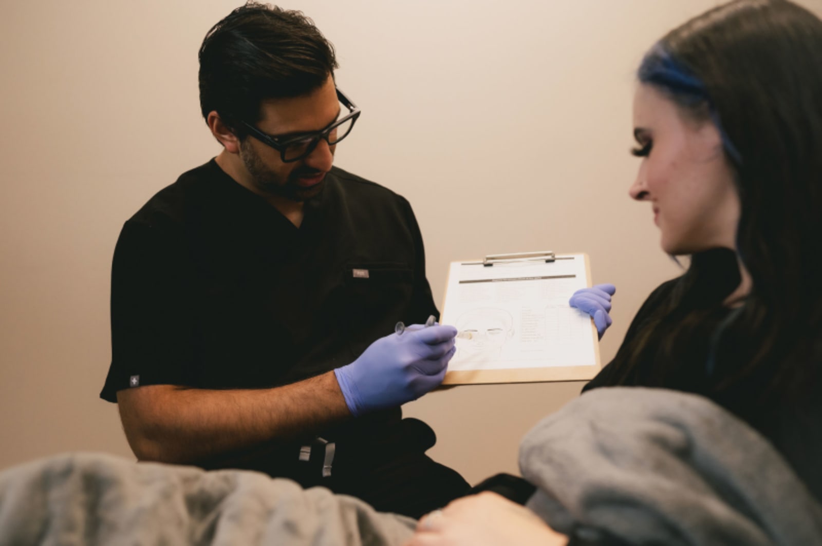 Dentist discussing treatment plan with patient, reviewing paperwork