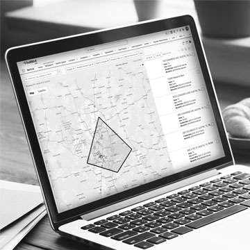 Computer sitting on desk with a mockup of Rethink's geo search feature