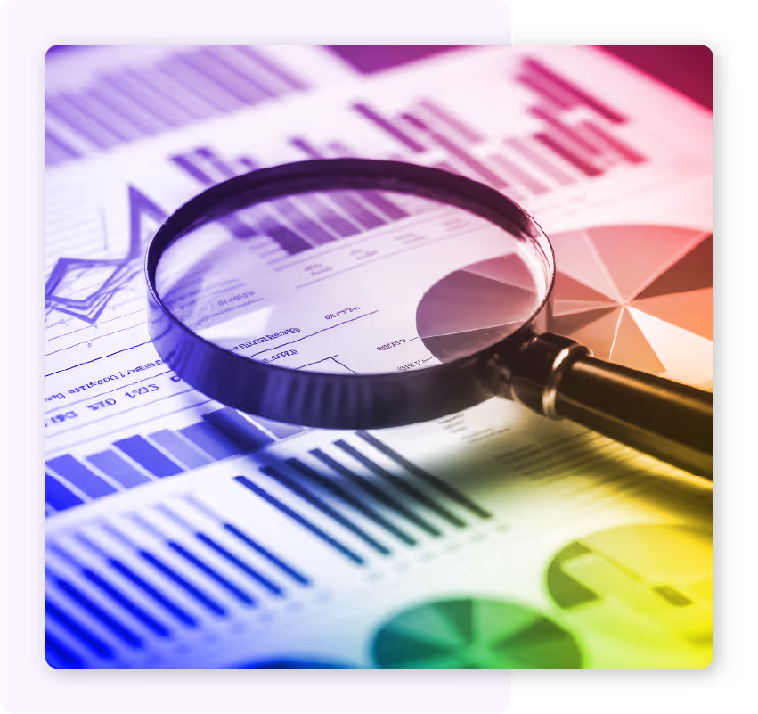Magnifying glass sitting on top of documents with charts and graphs