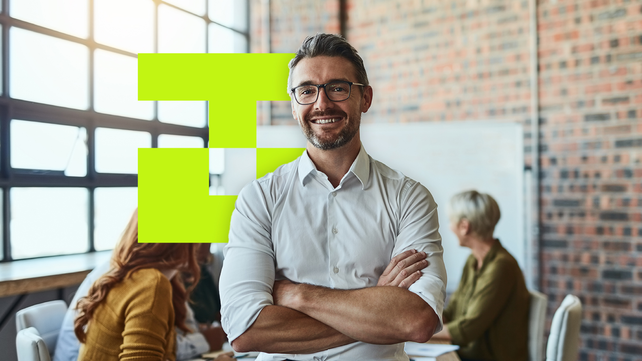 Confident businessman in glasses smiling with arms crossed in a modern office.