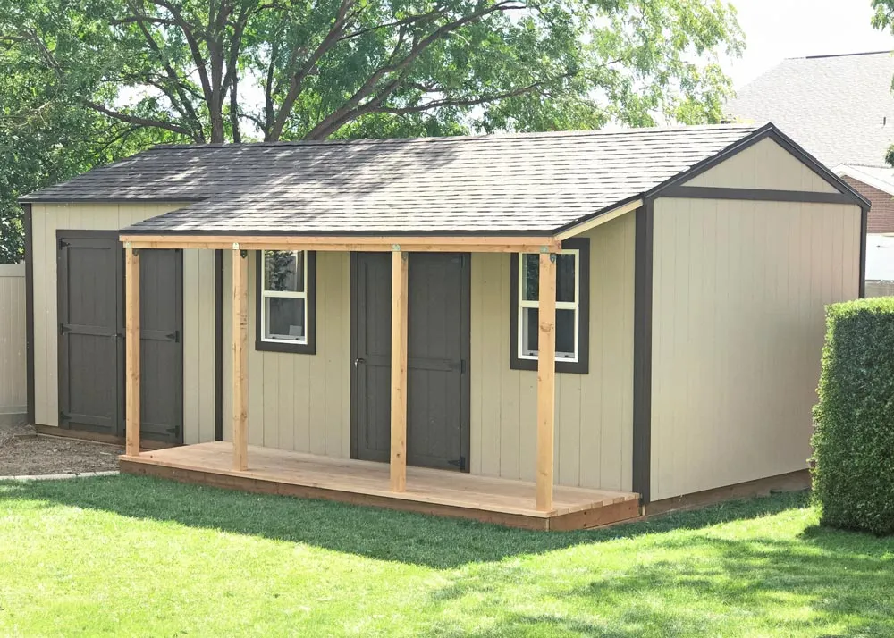 A custom 10 foot by 24 foot Tall Apex shed with a porch overhang on part of it.