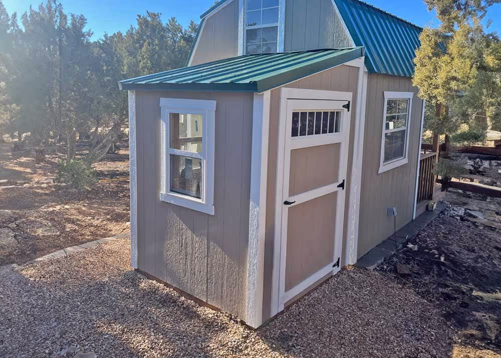 A small 6 foot by 6 foot lean-to style shed with a transom window in the door and a metal roof upgrade