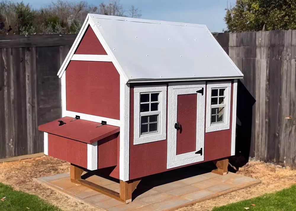 A large Hen Hut chicken coop in a corner