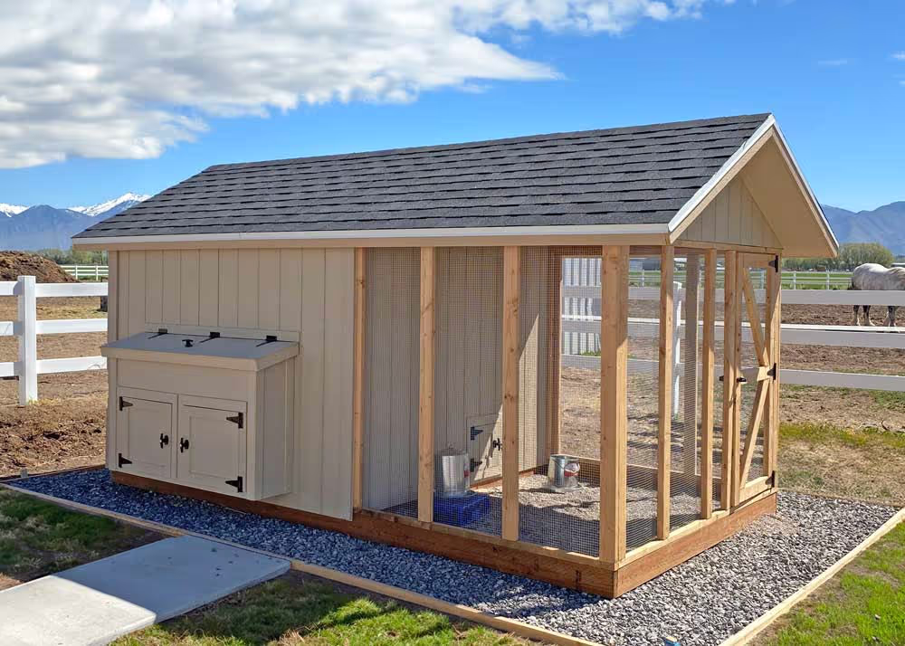 An unpainted 8 foot by 16 foot Coop De'Ville with a nesting box cabinet on the back side of the coop