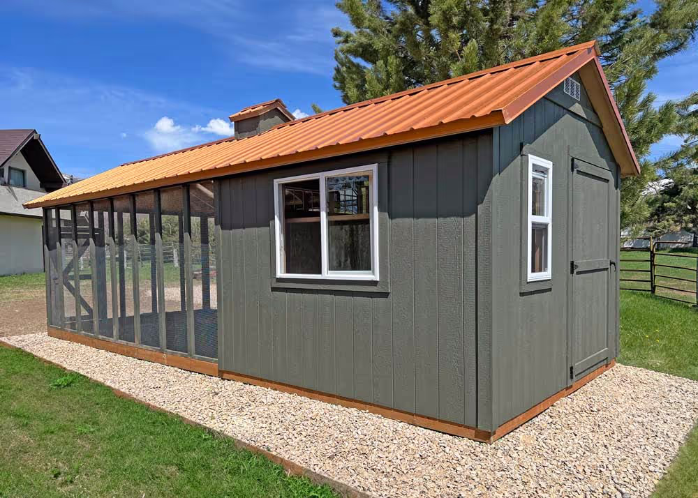 A custom shed turned chicken coop with a run and a copper metal roof
