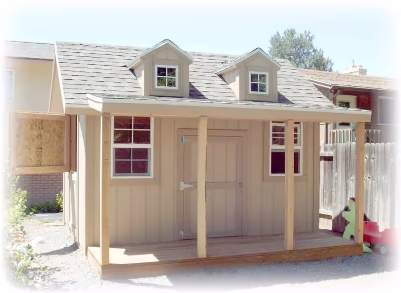 A custom playhouse with two a-frame dormers, a dutch door and a porch