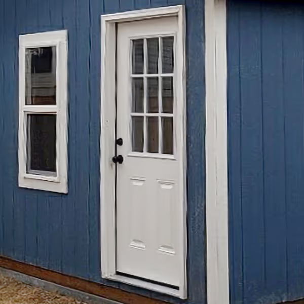 A 9-lite steel entry door on a tall apex shed.