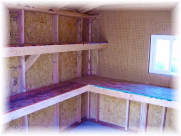 Interior of a shed with 16" deep shelves and a 24" deep workbench shelf