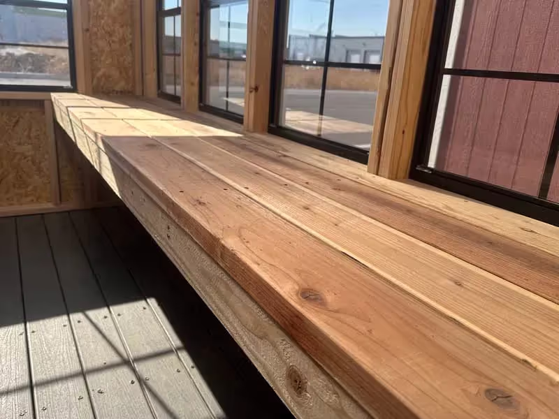 Interior of a greenhouse featuring a durable redwood workbench, perfect for gardening and potting tasks.