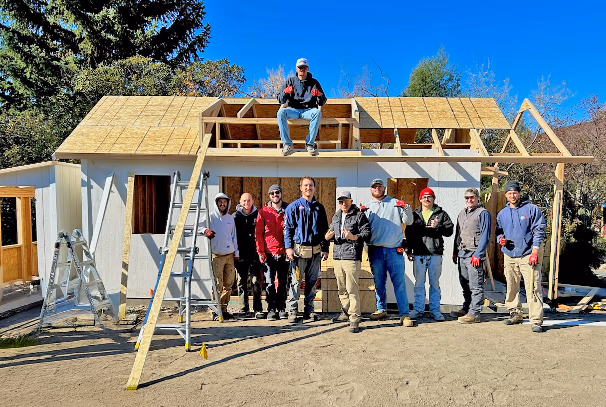 Apex Shed Company installation crews building multiple custom sheds on-site for a single customer