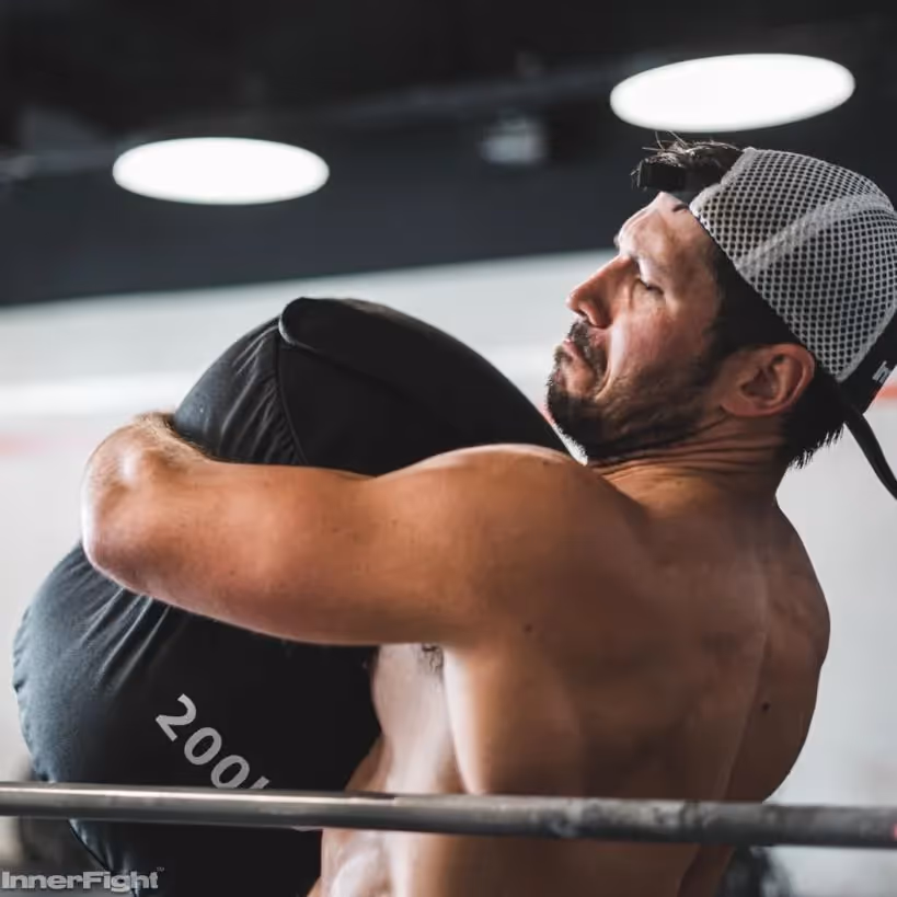 CrossFit athlete carrying a heavy sandbag