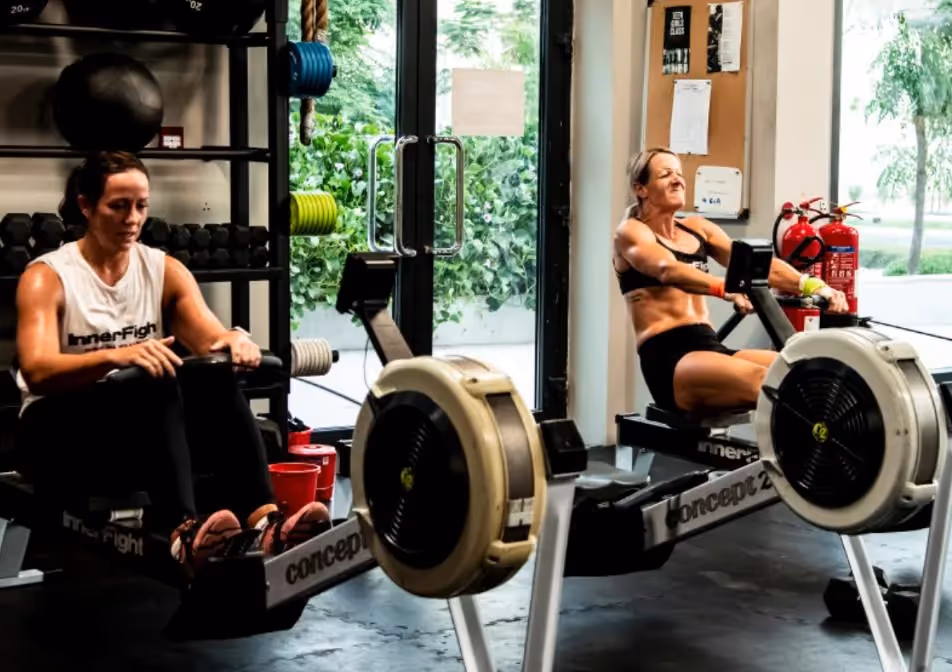 Two women doing Hyrox workout on rowing machines