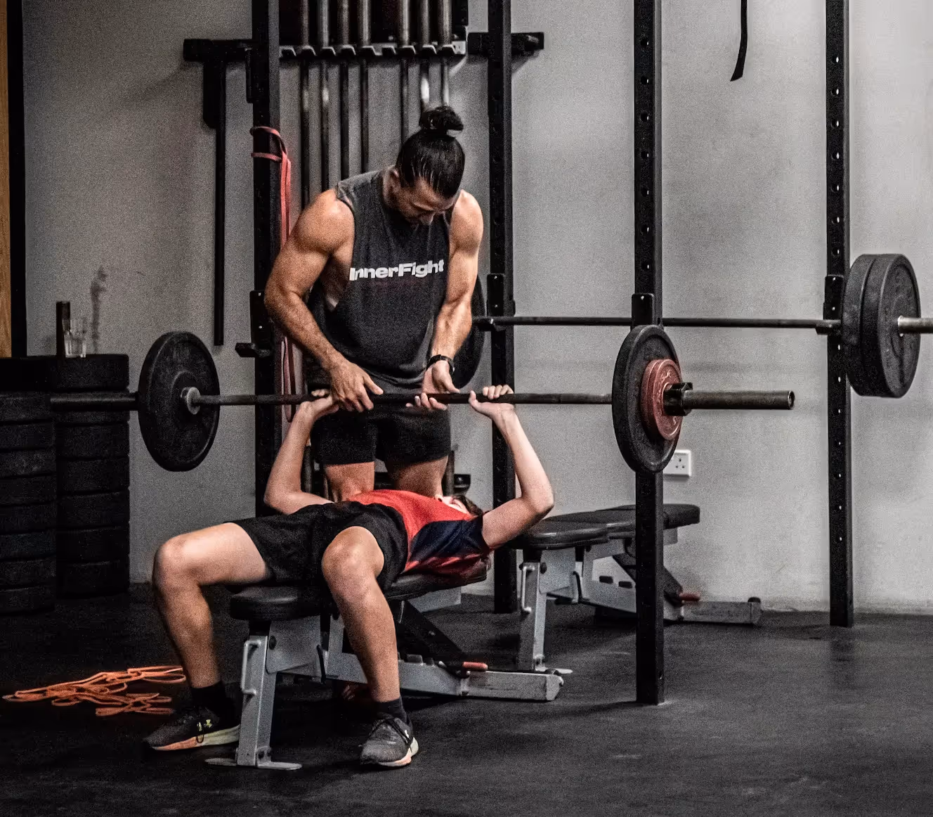 Fitness coach guiding a kid to use a gym equipment at InnerFight Gym Dubai