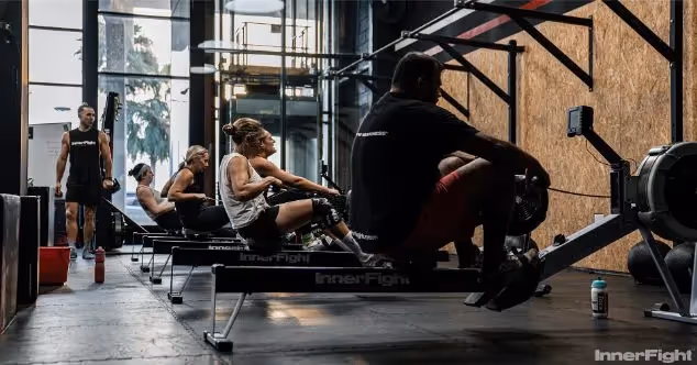 Athletes in a CrossFit class using rowing machines