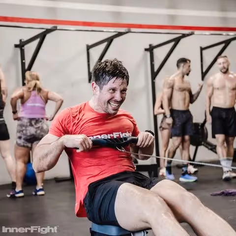 Male athlete on a rowing machine outside InnerFight Dubai