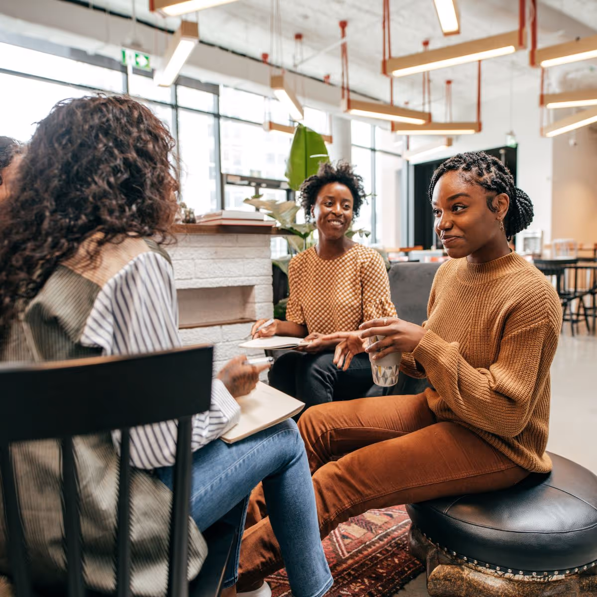 Co-workers speaking together in an office sharing ideas and collaborating on best EDI practices within their not-for-profit organization.