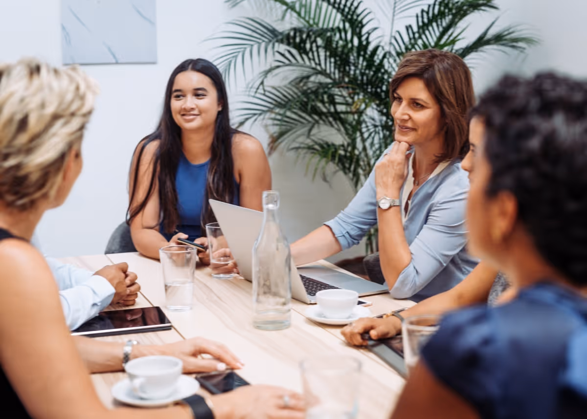 A group of coworkers sitting around a board room table comfortably.