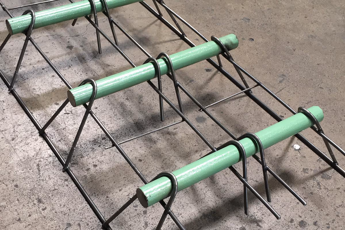 American Highway’s dowel baskets installed in warehouse concrete flatwork, ensuring stable load transfer for high-traffic joints. Close-up of American Highway’s dowel baskets in industrial flatwork, providing durable joint stability for heavy equipment loads.