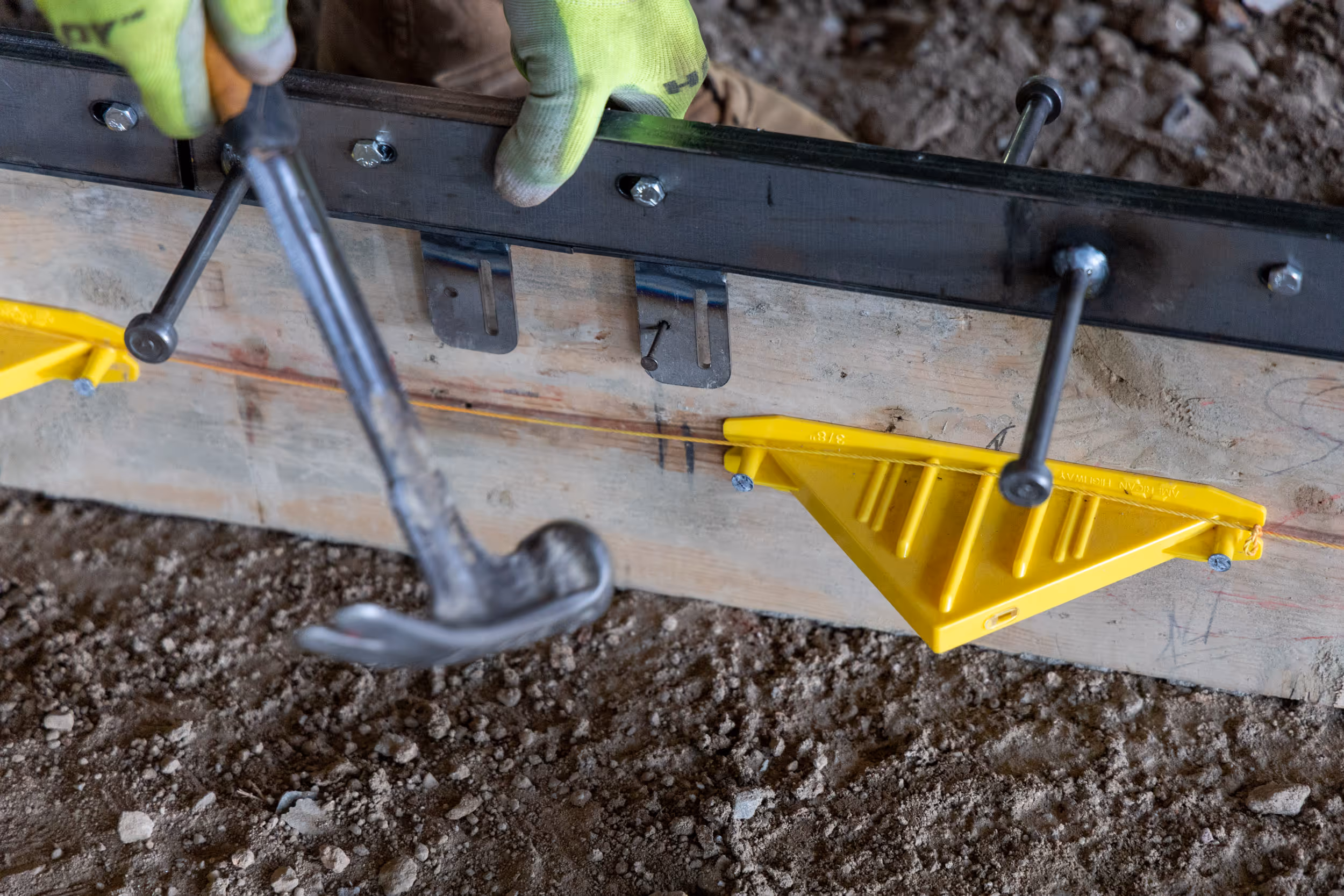 Iron-Clad joint assemblies by American Highway installed in commercial flatwork, showcasing high-tolerance steel bars and nylon nuts for spall-free concrete joints.