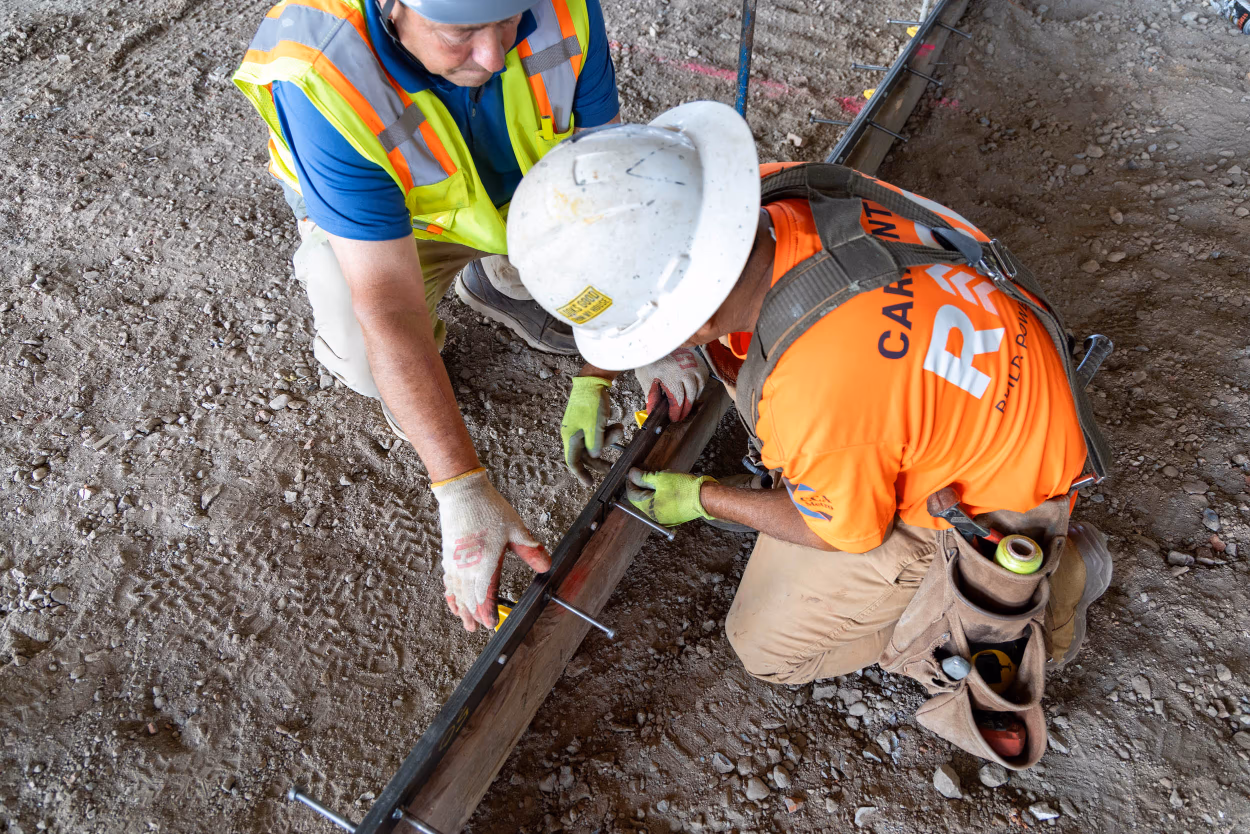Iron-Clad joint assemblies by American Highway installed in commercial flatwork, showcasing high-tolerance steel bars and nylon nuts for spall-free concrete joints.