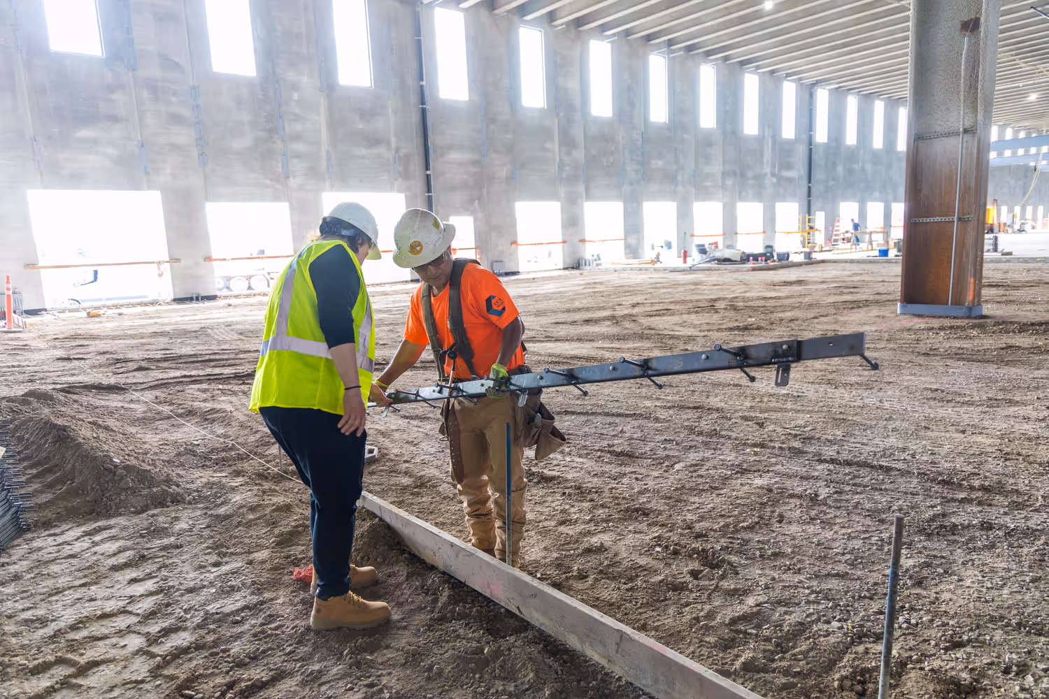Iron-Clad joint assemblies by American Highway installed in commercial flatwork, showcasing high-tolerance steel bars and nylon nuts for spall-free concrete joints.