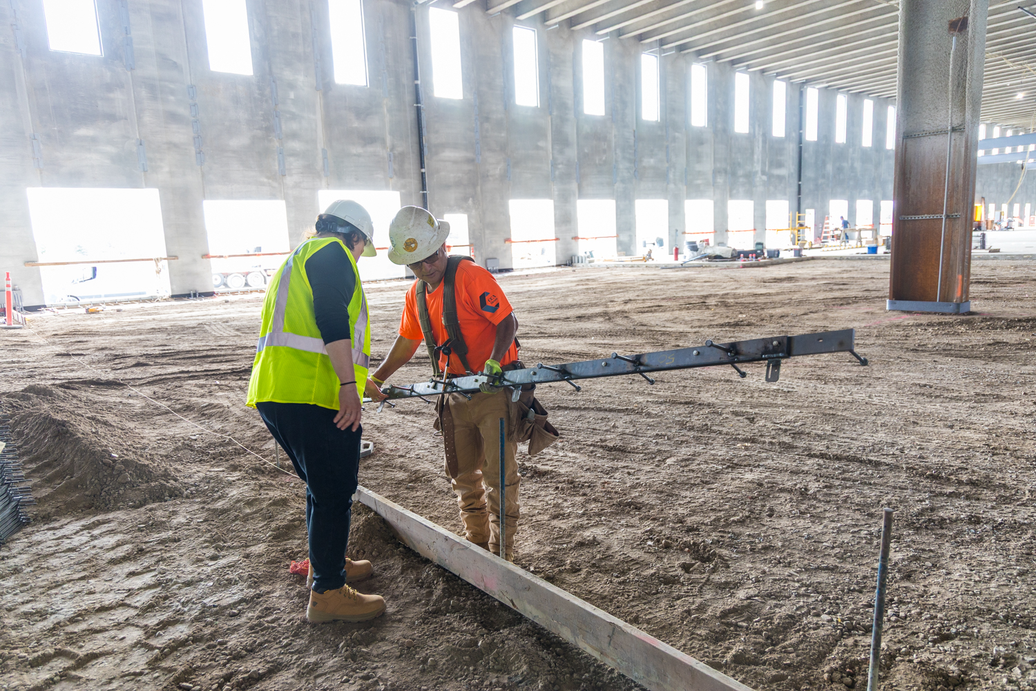 Iron-Clad joint assemblies by American Highway installed in commercial flatwork, showcasing high-tolerance steel bars and nylon nuts for spall-free concrete joints.