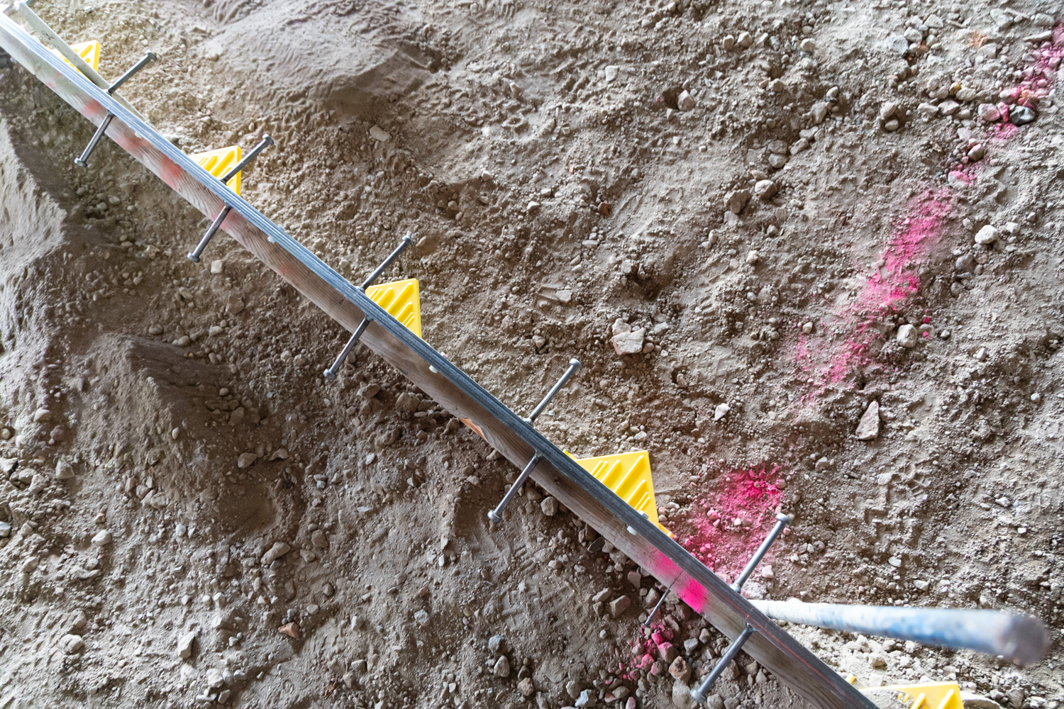 Iron-Clad joint assemblies by American Highway installed in commercial flatwork, showcasing high-tolerance steel bars and nylon nuts for spall-free concrete joints.