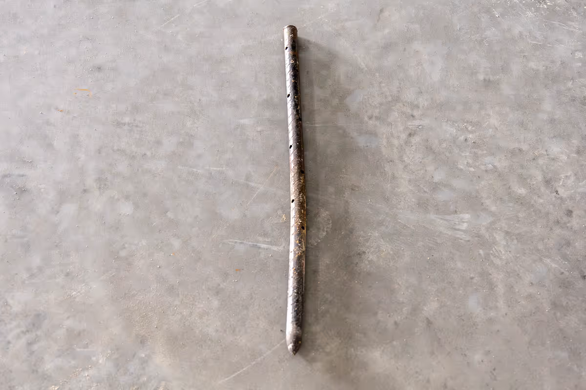 American Highway’s stakes, pins, and clips securing road fabric in warehouse concrete flatwork, ensuring stable, high-traffic durability. Close-up of American Highway’s pins and clips in industrial flatwork, aligning reinforcement for robust concrete performance.
