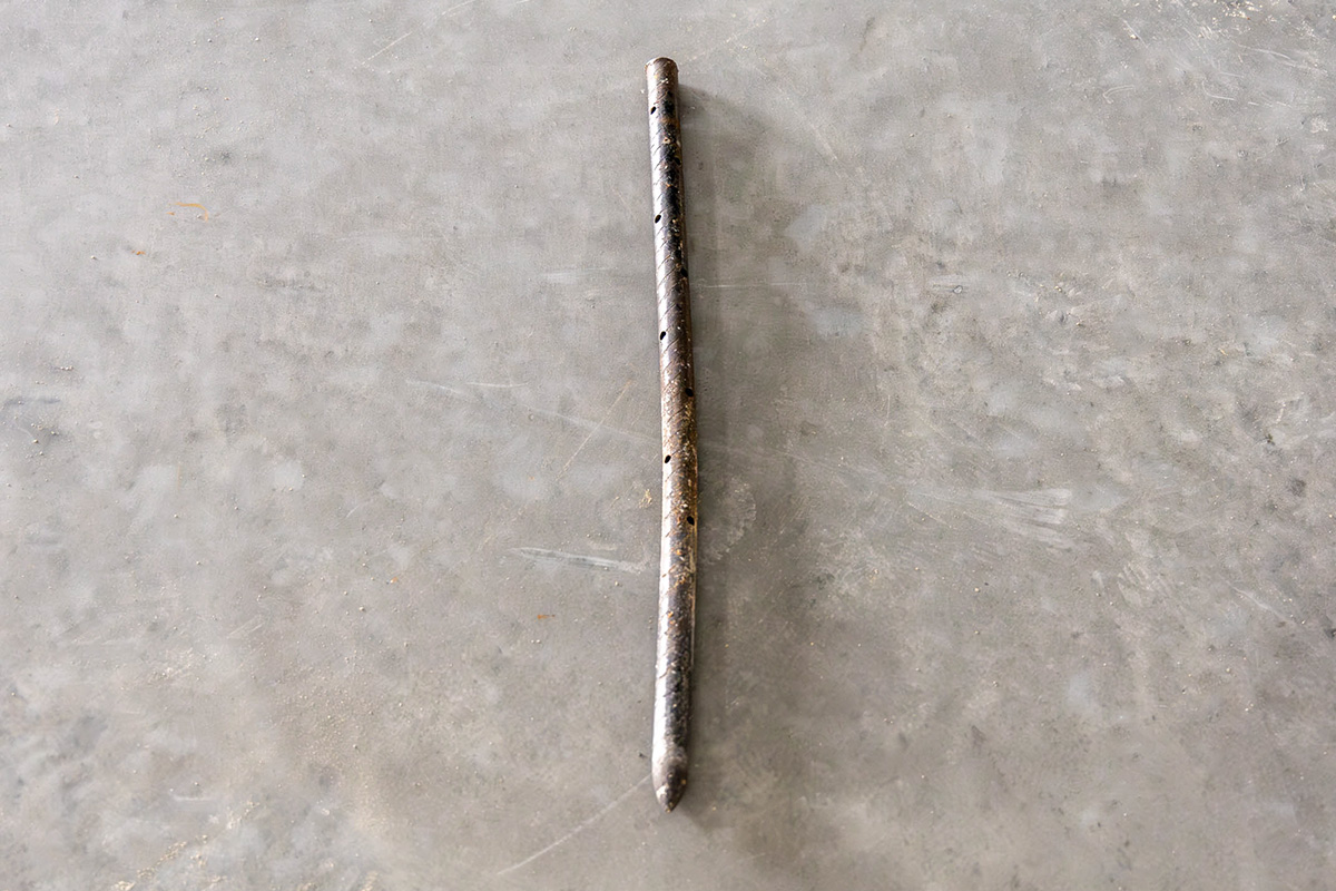 American Highway’s stakes, pins, and clips securing road fabric in warehouse concrete flatwork, ensuring stable, high-traffic durability. Close-up of American Highway’s pins and clips in industrial flatwork, aligning reinforcement for robust concrete performance.