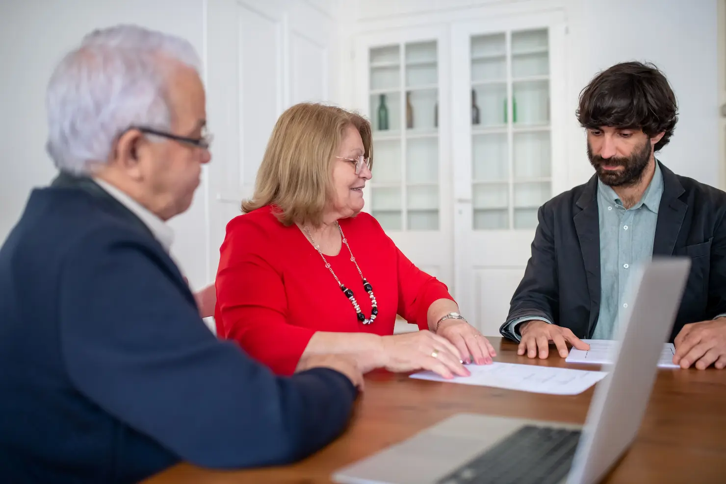 Un couple et un professionnel en affaires lors d'une réunion, discutant de documents