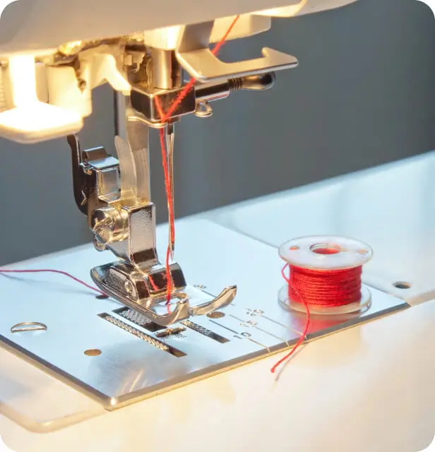 a close up of a sewing machine with a spool of thread