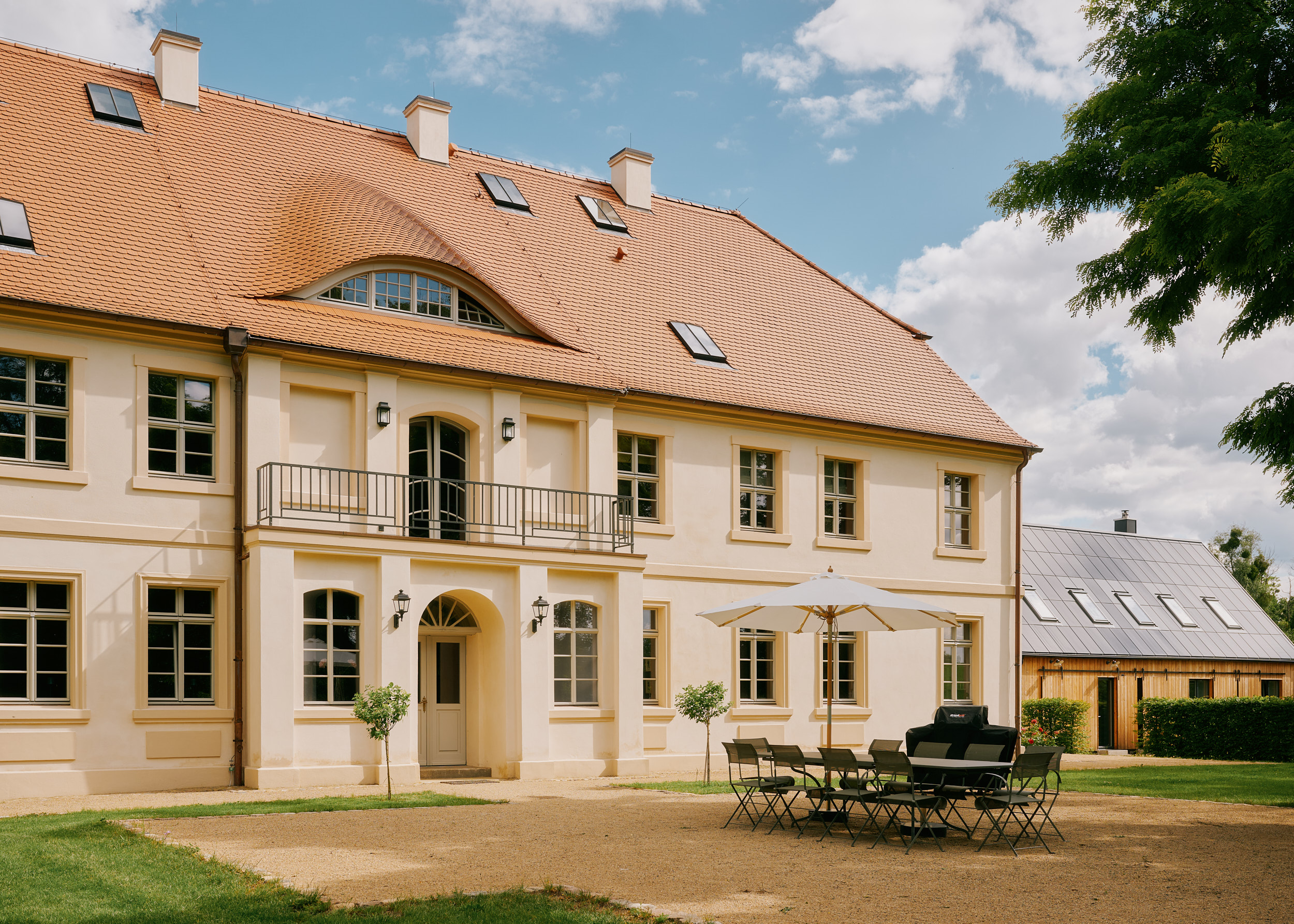 Spacious manor house with a wide front area, outdoor seating, and the nearby Kavaliershaus,