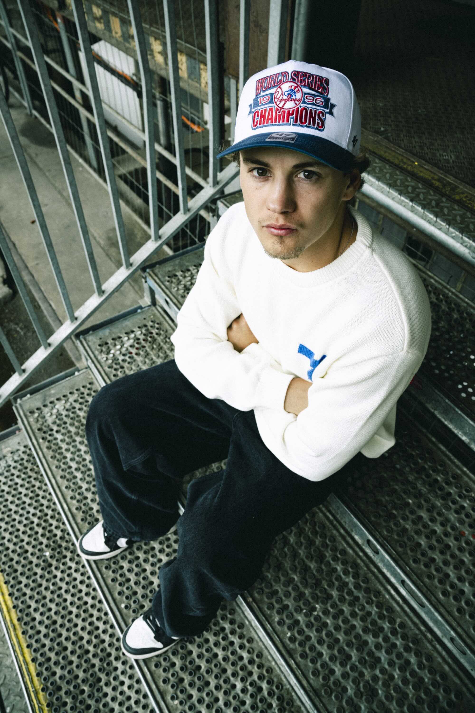 The artist Soleroy sitting on the stairs.