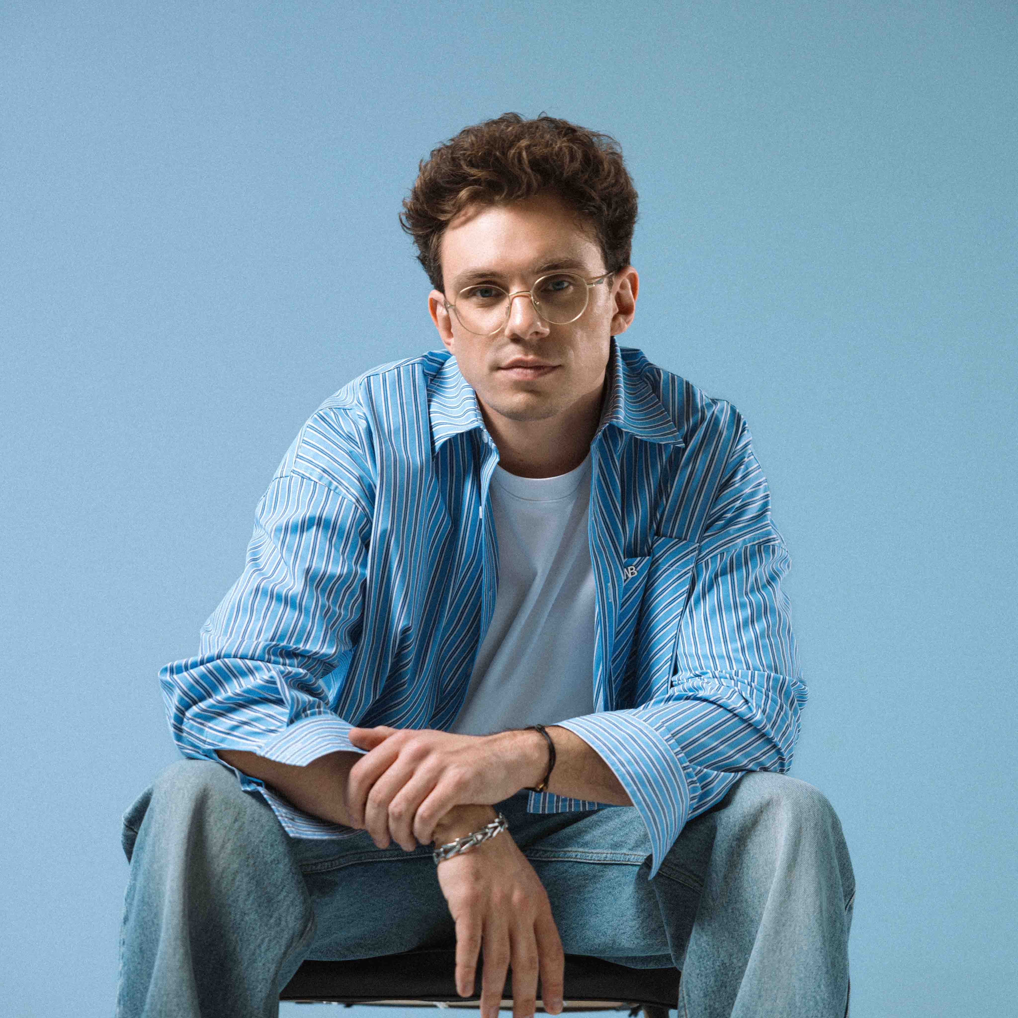 The artist kamrad in front of a blue wall