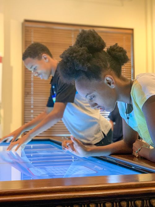 Two students look at and touch the interactive digital map in the Oklahoma Hall of Fame Gallery.