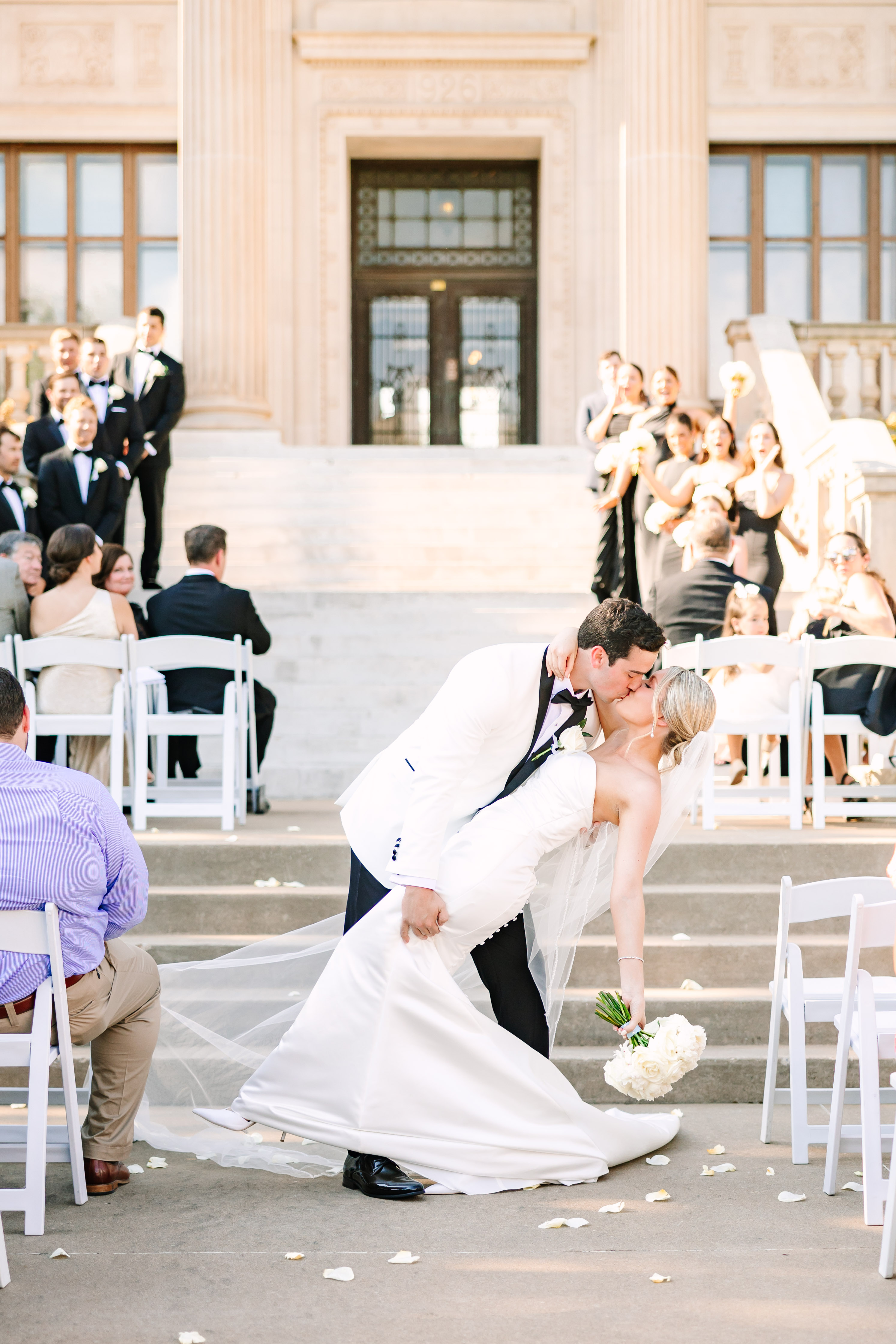 A bride and groom kiss during a wedding ceremony on the Oklahoma Hall of Fame grand staircase.