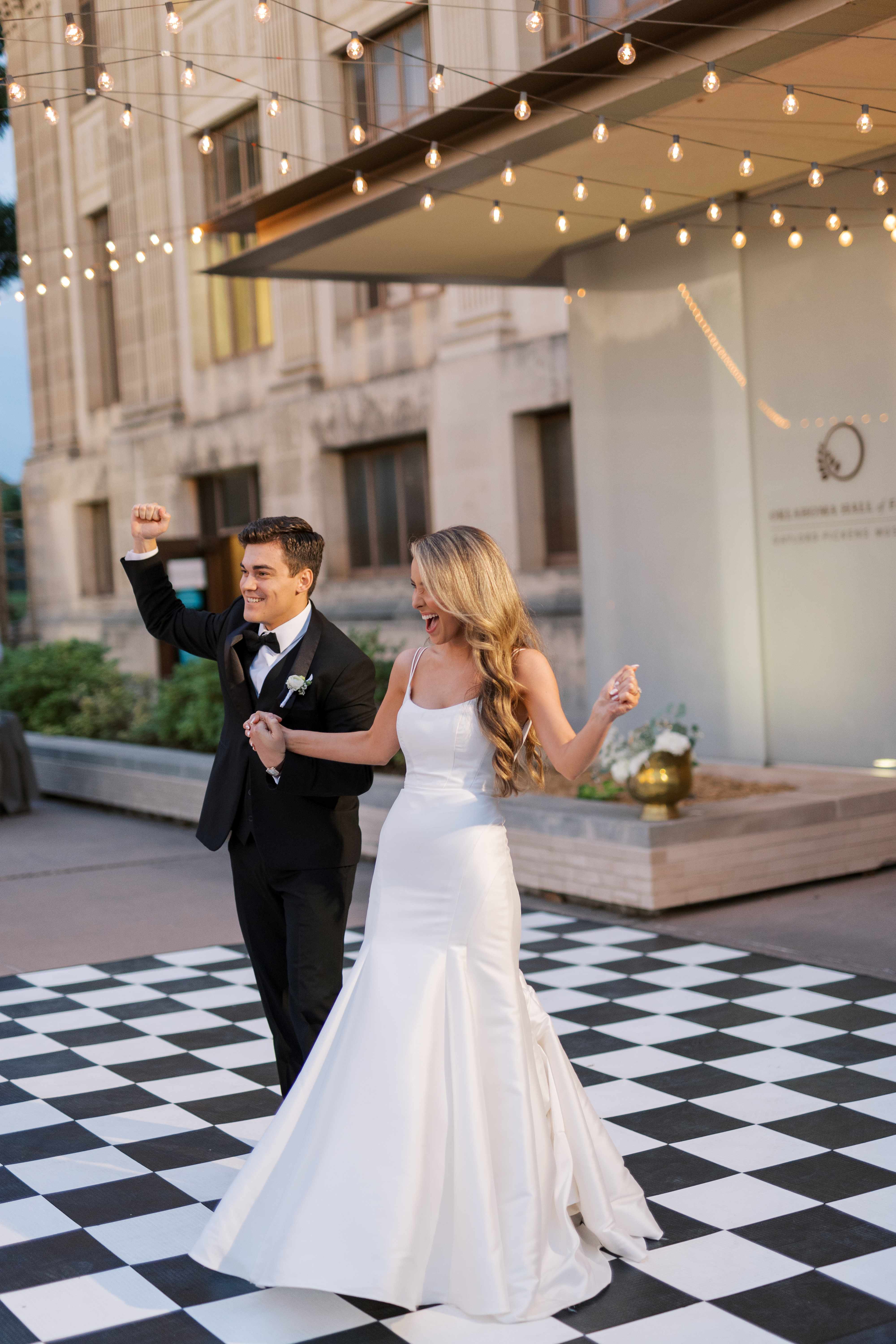 A bride and groom stand on the dance floor in the Oklahoma Hall of Fame garden.