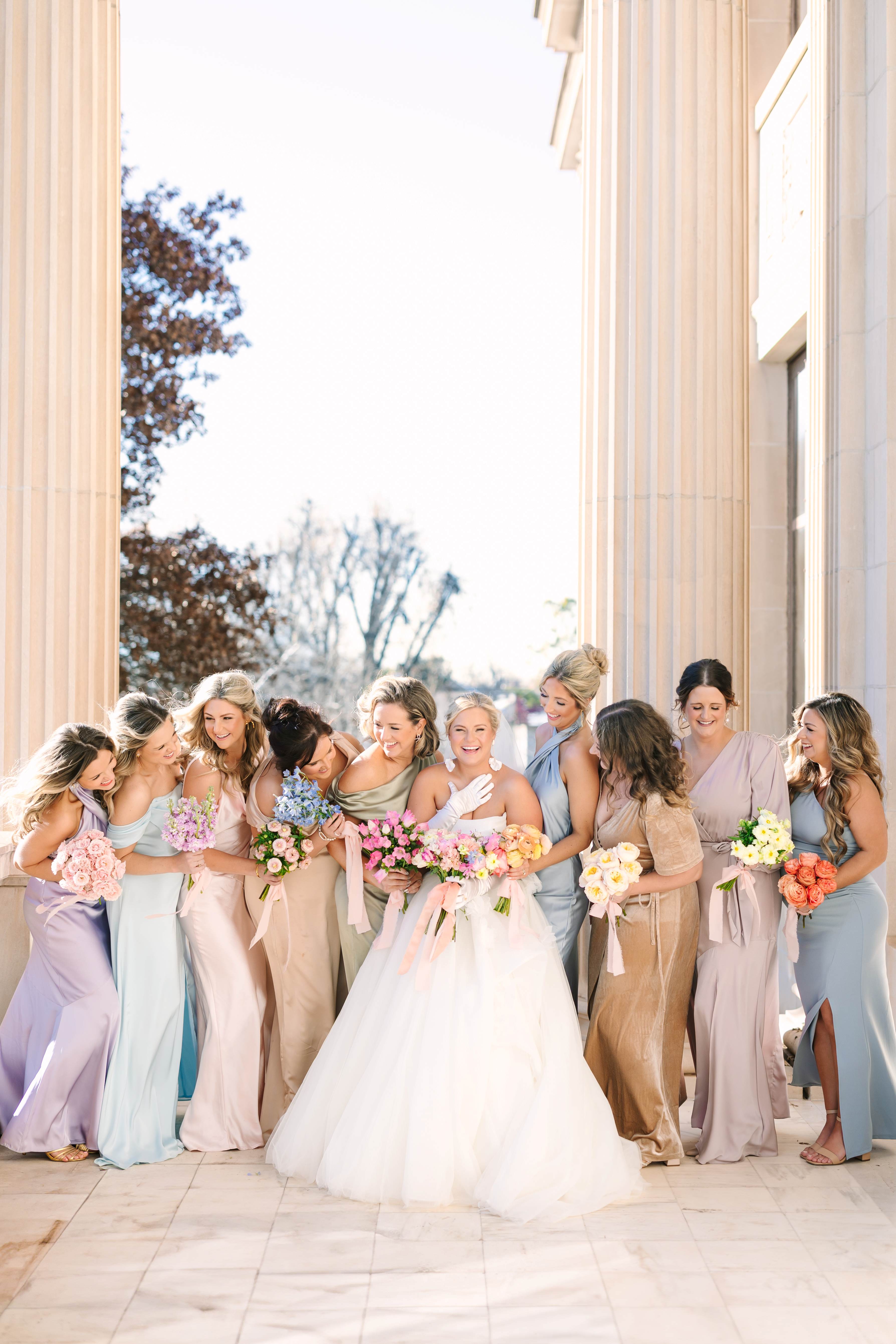 A bride and her bridesmaids pose by the front columns of the Oklahoma Hall of Fame.