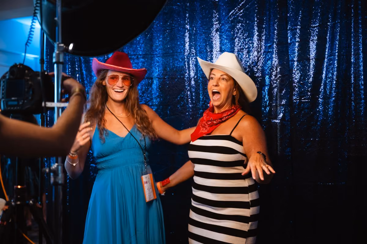 Two girls dressed up in cowboy hats and sunglasses pose for a photo.