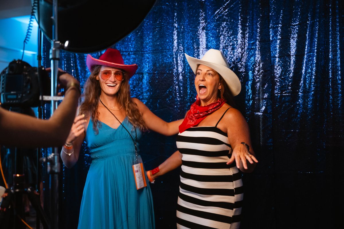 Two girls dressed up in cowboy hats and sunglasses pose for a photo.