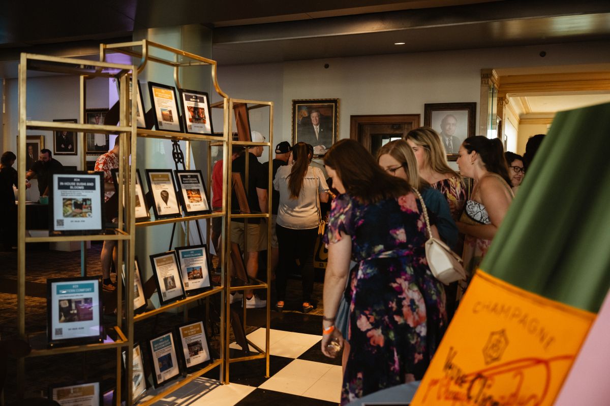 A group of women look at the silent auction package options.