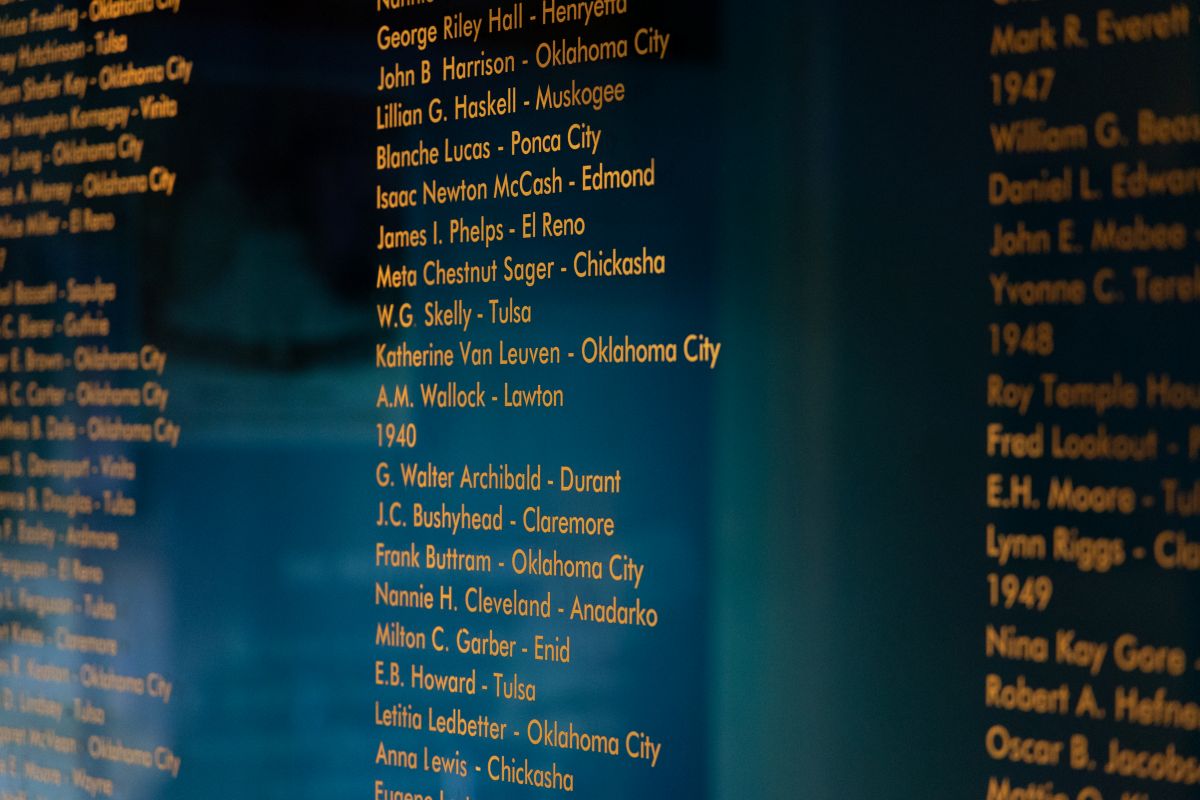 Close-up image of a blue glass wall with Inductee names, cities and years in gold lettering