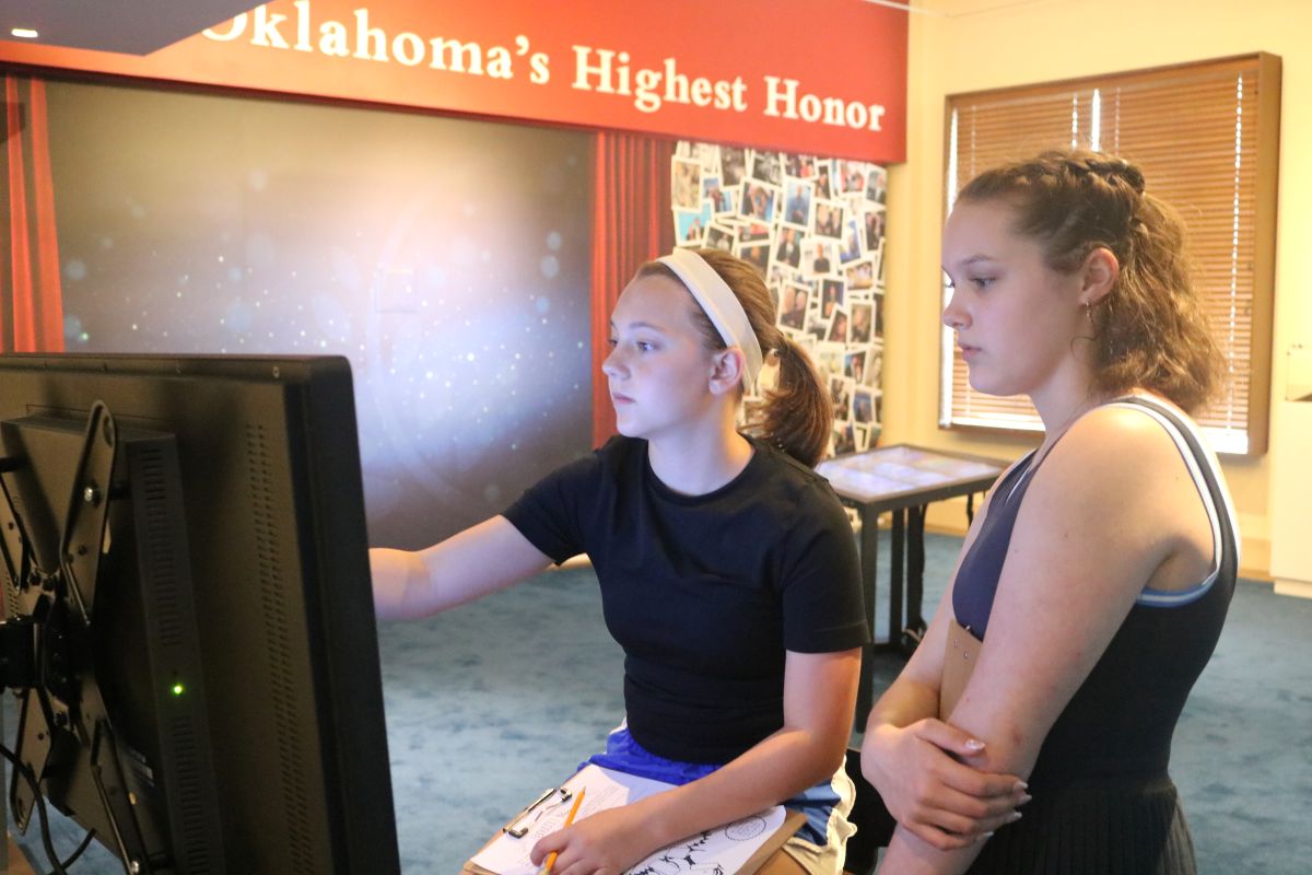 Two high school students explore the interactive Inductee Gallery via a touchscreen monitor